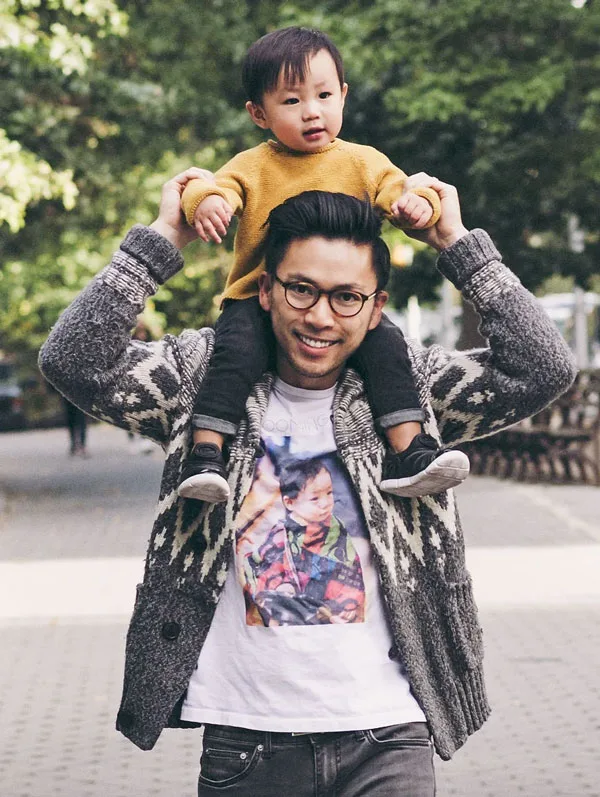 Dr. Lin holding his child on shoulders smiling