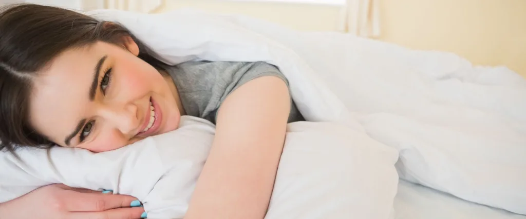 woman hugs pillow while learning about orthodontics and sleep apnea