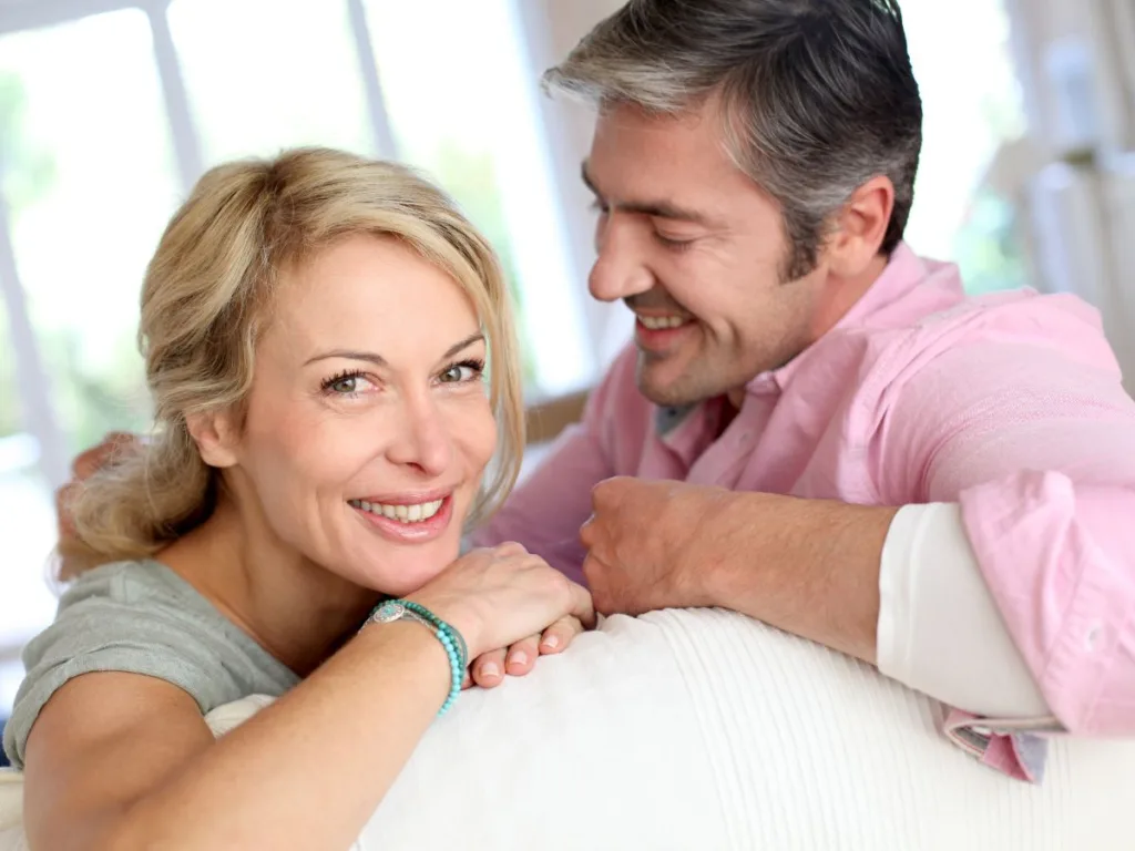 couple smiles on couch, wondering "can i switch orthodontists in the middle of treatment"